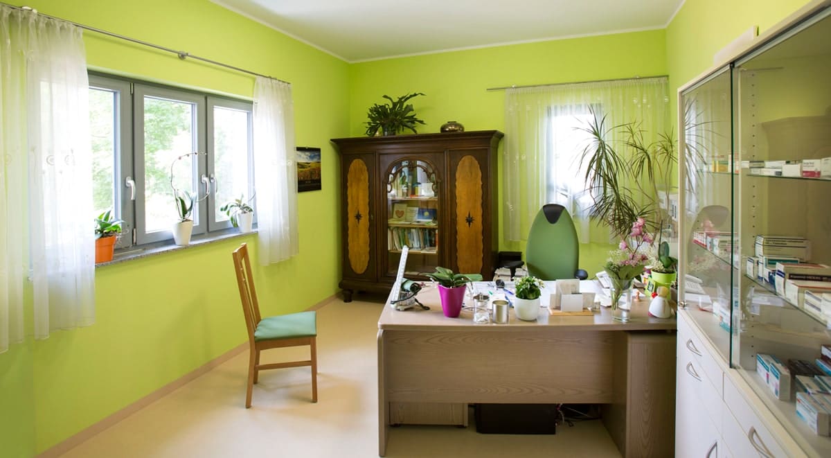 Zimmer mit grünen Wänden, Schreibtisch, Arzneimittel- und Bücherschrank